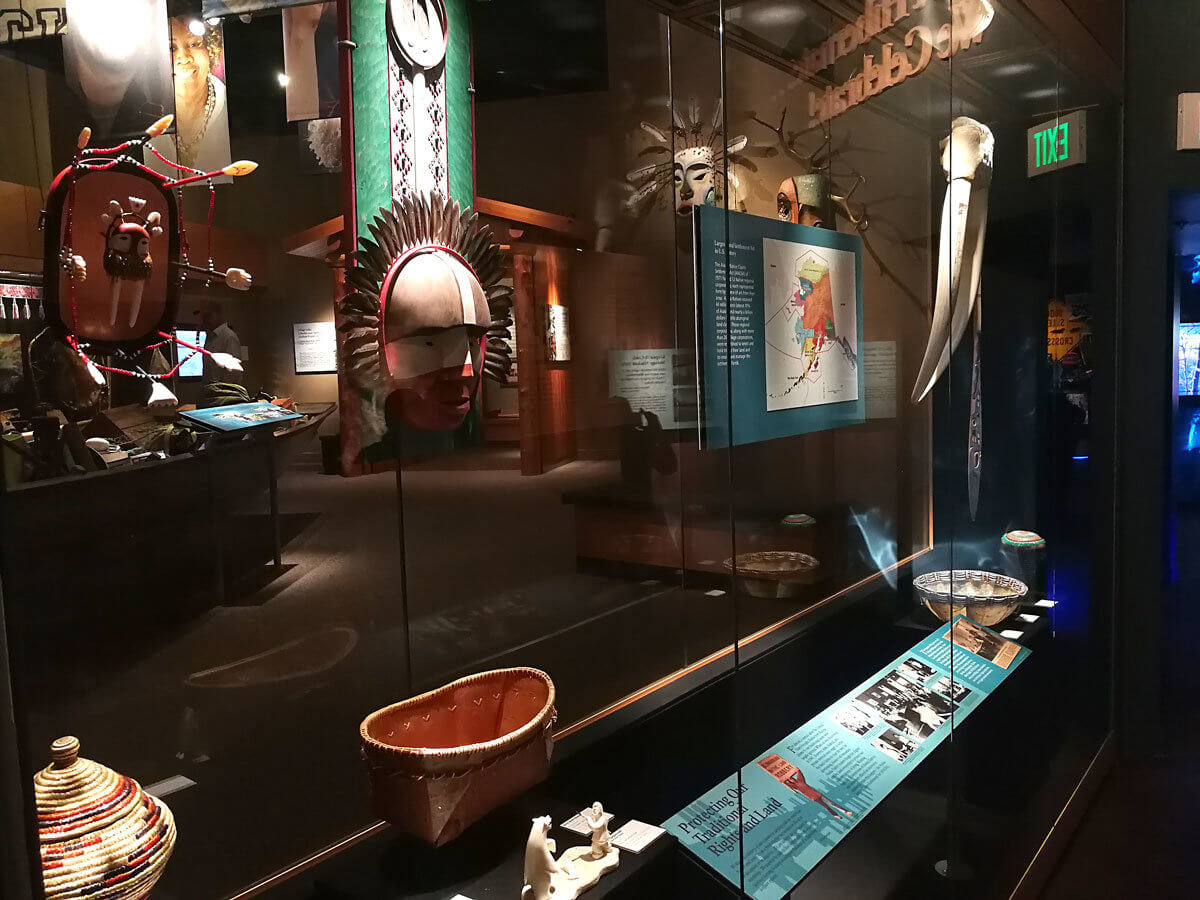 Museum case of traditional Alaskan crafts and masks