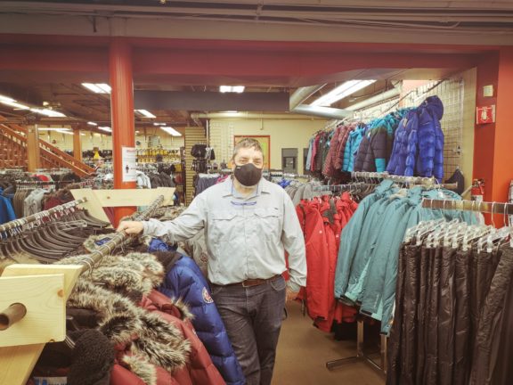 Steve stands near racks of clothes at Big Ray's