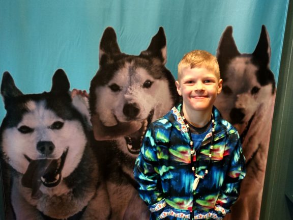 Child posing in front of life-size wolf photos