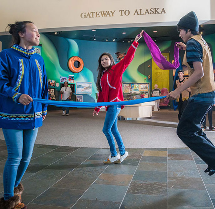 Youth performs traditional Alaska Native dance in the Morris Thompson Center lobby.